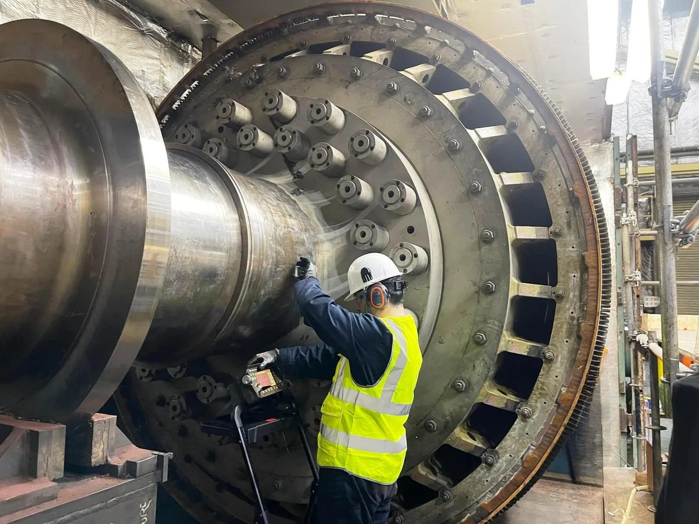 CMH Metlabs engineer performing on-site non-destructive testing on a large industrial turbine assembly